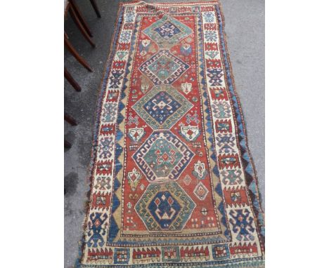 An Antique Turkish Runner, the runner having five central ghouls to inner panel with tribal motive to outer border, approx 26