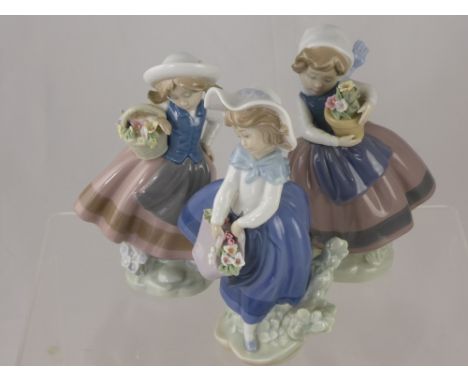 Three Porcelain Lladro Figurines, depicting little girls with baskets of flowers, approx 17cms high. (3)