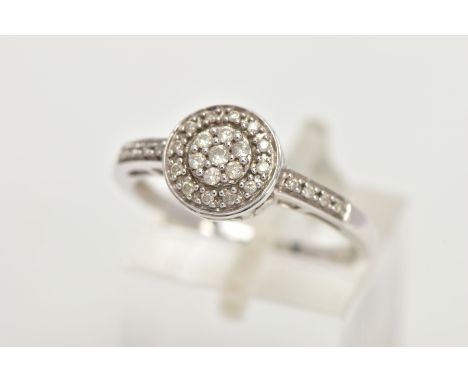 A 14CT WHITE GOLD DIAMOND RING, of a circular design, set with round brilliant cut diamonds and round brilliant cut diamond d