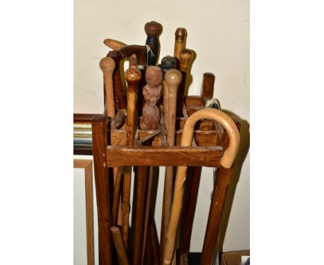 A WOODEN STICK STAND AND CONTENTS, the stand with sixteen small divisions, width and depth 33.5cm height 93.5cm, together wit