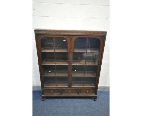 AN EARLY TO MID 20TH CENTURY OAK GLAZED TWO DOOR BOOKCASE, with three adjustable shelves, later lighting fitted, over three d