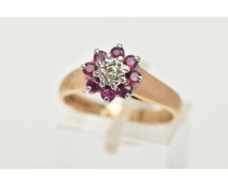 A 9CT GOLD RUBY AND DIAMOND CLUSTER RING, flower shape cluster set with a central round brilliant cut diamond in a surround o