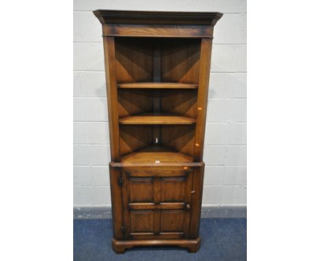 A SOLID OAK OPEN CORNER CUPBOARD, with two fixed shelves, over a single fielded panel cupboard door, width 81cm x depth 44cm 