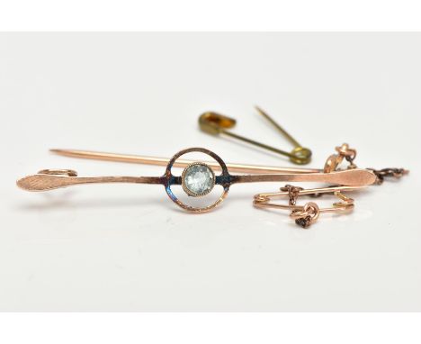 A YELLOW METAL AQUAMARINE BAR BROOCH, set centrally with a circular cut aquamarine in a milgrain collet mount, openwork circu