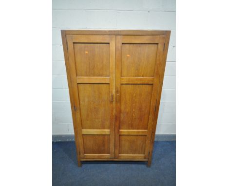 HEAL &amp; SON LTD OF LONDON, AN ARTS AND CRAFTS LIMED OAK PANELLED TWO DOOR WARDROBE, enclosing a single shelf, and circular