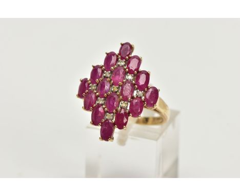 A 9CT GOLD RUBY AND DIAMOND CLUSTER RING, of a lozenge shape, set with a cluster of oval cut rubies with single cut diamond d