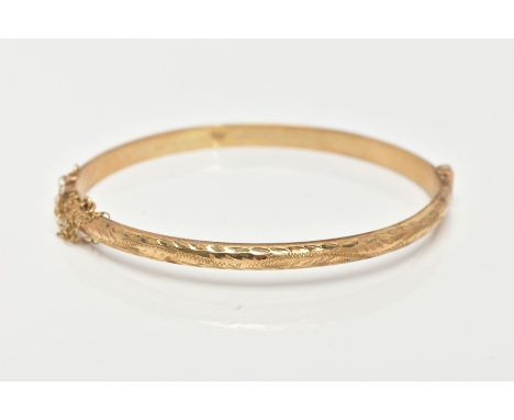 A 9CT GOLD HINGED BANGLE, diamond cut pattern to one side, plain polished to the other, sliding clasp with additional safety 