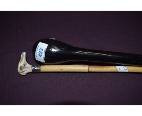 An ebonised police or knocking stick  91cm long and a small cane stick 77cm long with carved horn birds head and a silver col