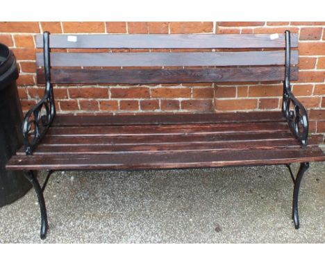 A metal end and wooden slat garden bench