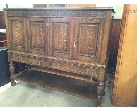 A 1930's oak buffet sideboard, blind network frieze above 4 outward opening doors with storage and shelves within, above to l