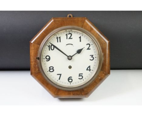 Art Deco oak cased octagonal wall clock with cream dial, Arabic numerals and poker hands. Measures 28cm wide 