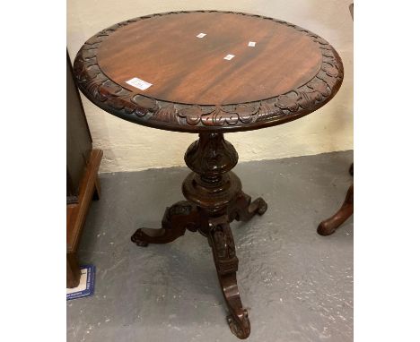 Victorian design mahogany lamp table, the circular moulded and carved top above an ornately carved pedestal on tri-form base.