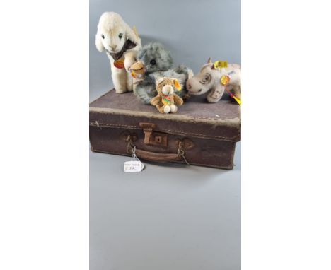 A collection of Steiff animals, to include: two lambs, baby rhinoceros, duckling and a teddy bear keyring in a small vintage 