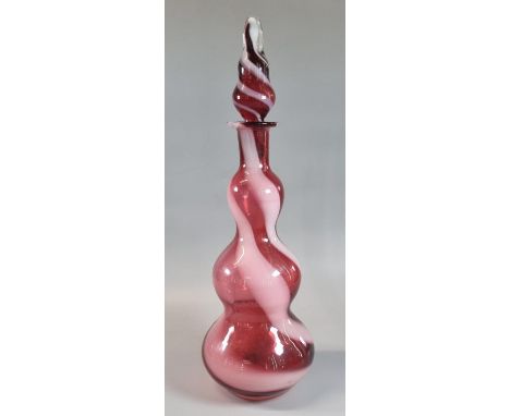 Ruby wrythen combed glass triple baluster shaped decanter with blown stopper. 36cm high approx. (B.P. 21% + VAT) 