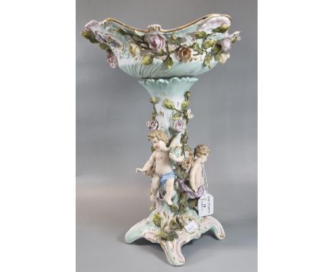 A Sitzendorf German porcelain table centre piece with floral decoration and cherub mounts. Hatched under glazed blue mark to 