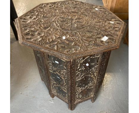 Early 20th century ornately carved octagonal folding lamp table, carved overall with leaves and berries.   (B.P. 21% + VAT) 
