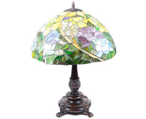A Tiffany style table lamp, with large shade decorated with flowers, predominately in green, purple and blue, on a metal stan