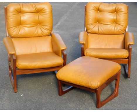 A pair of vintage teak framed armchairs, each with ladder backs and removable button cushions, with overstuffed arms and seat