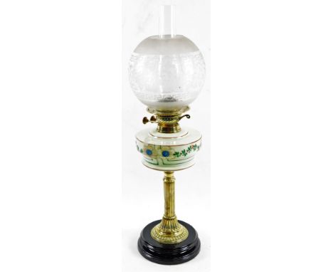 A late Victorian oil lamp, with clear and frosted glass shade, clear chimney, painted milk glass reservoir and brass stem, on
