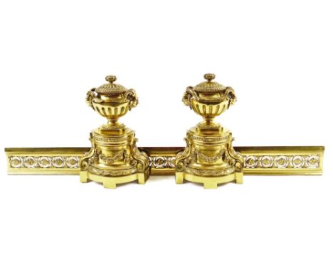 A Regency style metal fire surround, comprising of a pair of andirons surmounted by urns with satyr mask heads, with fixed li