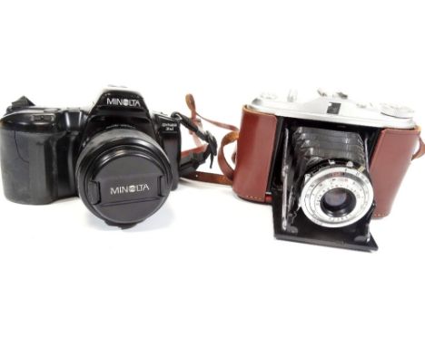 A Minolta camera, with power zoom 35:80mm 1:4 (22)-5.6 49mm AF lens, the camera 9cm H and a Isolette camera in brown leather 