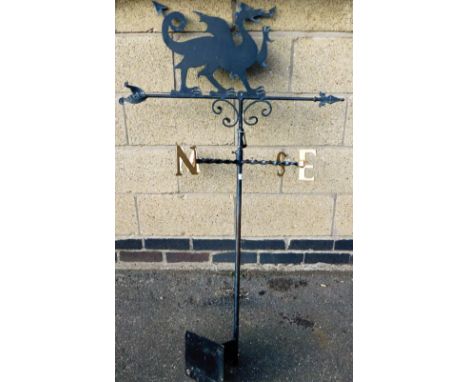 A 20thC wrought iron weather vane, headed by a dragon, on cylindrical stem with rectangular back mount and N E S and W sectio
