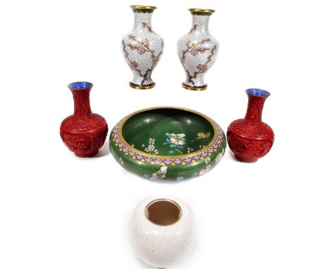 A pair of Chinese cinnabar vases, each of shouldered circular form, with cylindrical stems, profusely decorated with flowers,