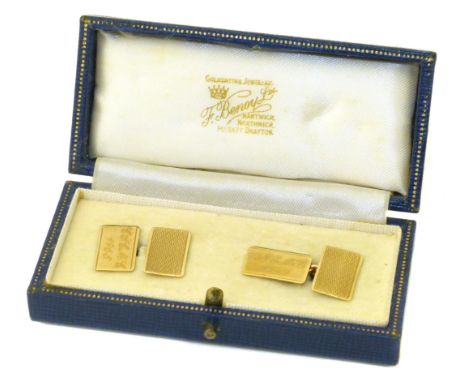 A pair of 9ct gold cufflinks, each designed as a pair of engine turned and polished rectangular panels with trace link chain 