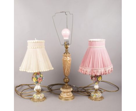 Three table lamps with shades. To include an Onyx and gilt metal lamp with pink shade and two matching floral  ceramic and gi