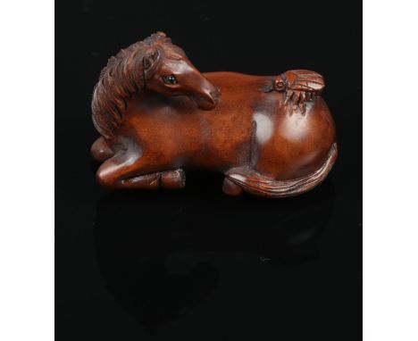 A carved hardwood Chinese netsuke. A sitting Horse with fly on back. 4.5cm length.  