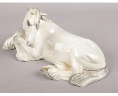 A Beswick model of a recumbent white shire horse.  Chip to ear.