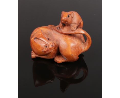 A carved hardwood Chinese netsuke. Cat with rat on tail. 5cm length.  
