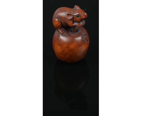 A carved hardwood Chinese netsuke. Rat sat on a apple. 5cm height.  