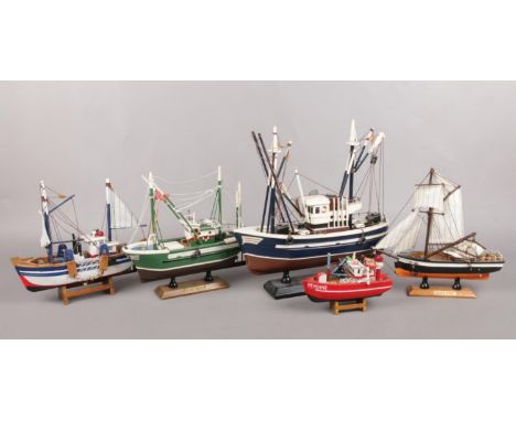 Five painted wooden model fishing boats. Largest: H: 31cm, W: 31cm.  