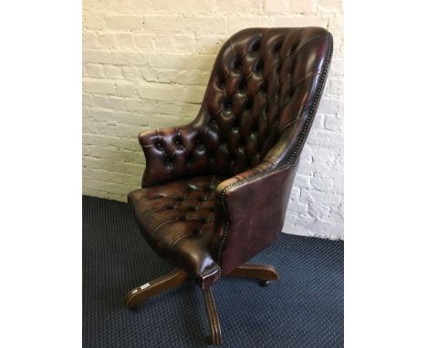 An oxblood leather deep button back and seat executive office elbow chair.