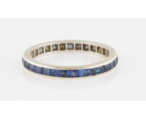 A sapphire full eternity ring, set with square cut sapphires, in unmarked white metal, ring size Q.