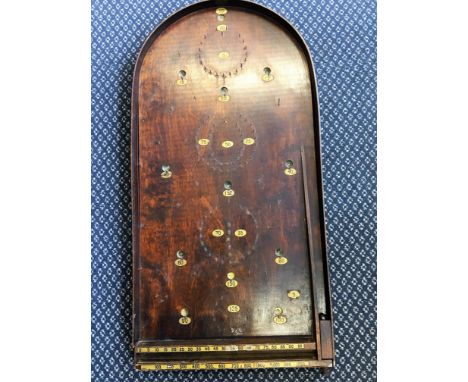 A stained wood bagatelle game with metal balls.