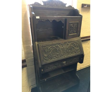 A carved oak bureau bookcase with open shelf base.