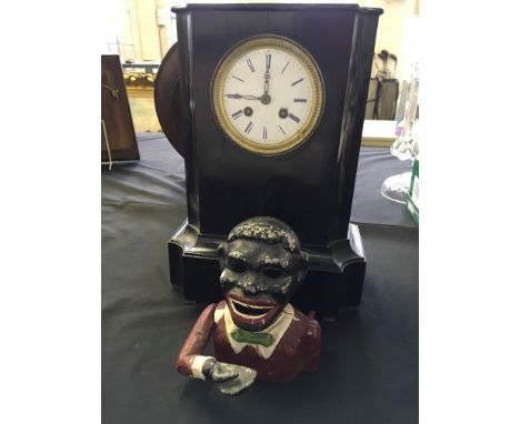 A black cased French mantle clock with white enamel dial and a Jolly Boy money box.