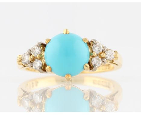 An 18ct yellow gold turquoise and diamond ring, set with a central circular turquoise cabochon, flanked to either side with t