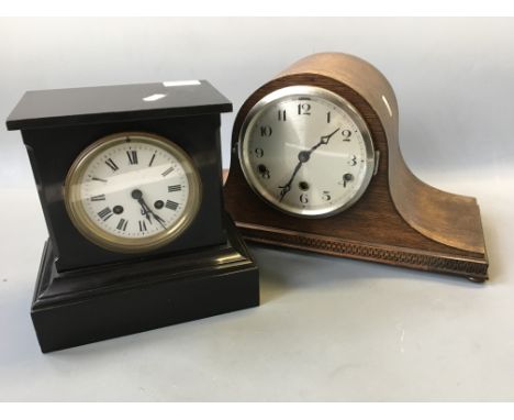 A black slate cased mantle clock and an oak cased mantle clock.