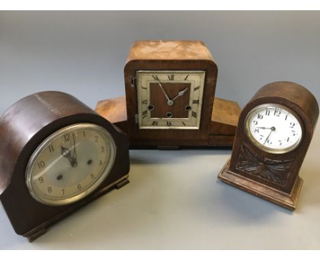 Three wooden mantel clocks in various shapes.