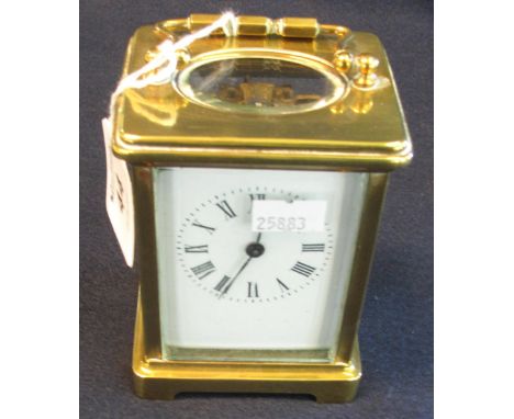 French brass carriage clock with full depth Roman enamel face, swing handle and key. 12 cm high.(B.P. 24% incl. VAT)