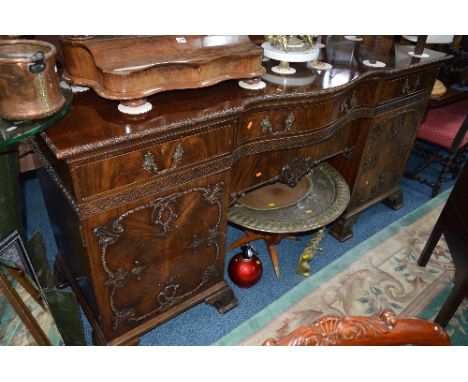 AN EARLY 20TH CENTURY CHIPPENDALE STYLE MAHOGANY SIDEBOARD, serpentine centre with central drawer, flanked by cupboards and d