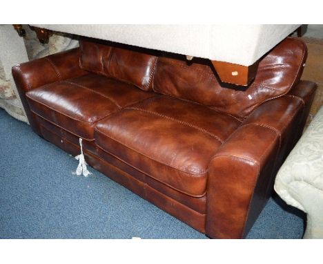 A TAN LEATHER TWO SEATER SOFA BED