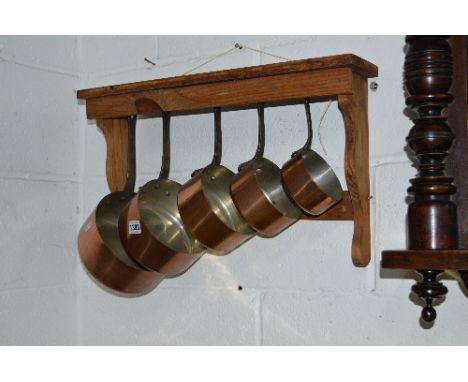 A SET OF FIVE GRADUATING COPPER PANS WITH IRON HANDLES and pine wall bracket (6)