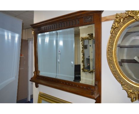 AN OLD CHARM OAK BEVELLED EDGE OVERMANTLE MIRROR, with a single shelf