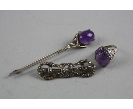 THREE PIECES OF SILVER JEWELLERY, to include an Amethyst carved ring, an Amethyst brooch and another brooch (3)