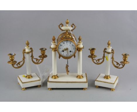 A LATE 19TH CENTURY WHITE MARBLE AND GILT METAL CLOCK GARNITURE, the clock with urn finial and bow above a circular enamel di