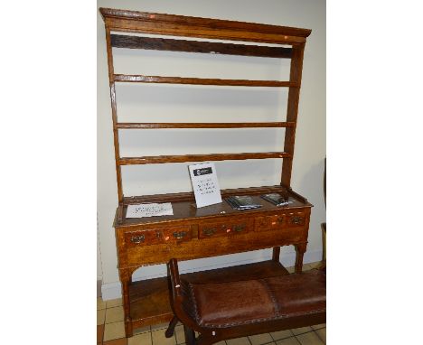 AN EARLY 20TH CENTURY OAK DRESSER, with a three tier plate rack, three short drawers with brass swan neck handles and escutch